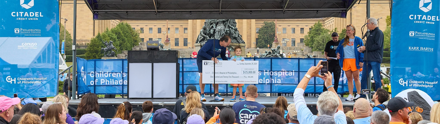 John Glomb holding a donation Check with the Griffin Family.