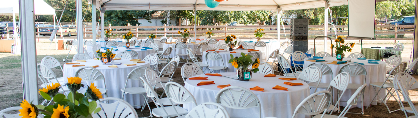 Tables under a tent with multi-color decorations for a private event.