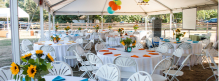 Tables under a tent with multi-color decorations for a private event.