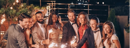 Image of crystal glasses full of champagne held by friends gathered at a one-day event. 