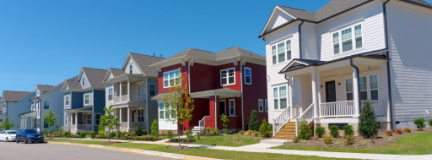 Six 20th-century Traditional-style homes line street in a suburban planned community that needs HOA insurance.