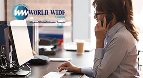 A female temporary office worker multitasking between a phone call and her computer. 