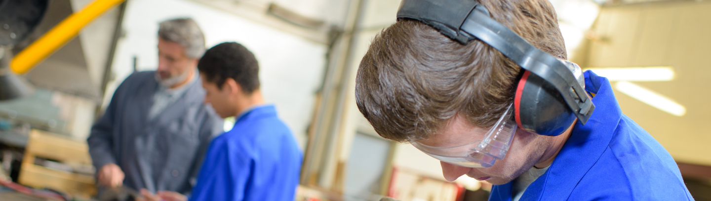 Young Man in blue using angle grinder