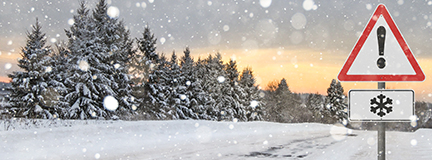 Snowy landscape with a traffic sign warning of winter weather