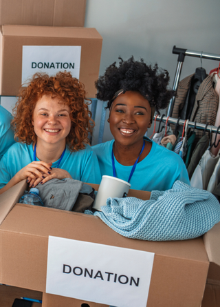 Group of four people smiling at camera collecting various donations. 