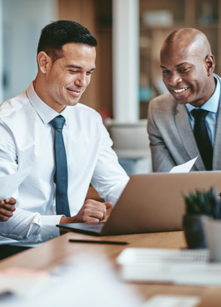 Close-up of three diverse business people looking at something on a laptop screen. 