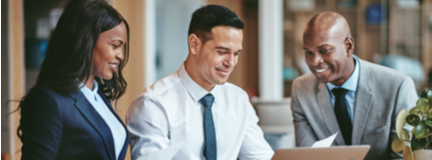 Close-up of three diverse business people looking at something on a laptop screen. 