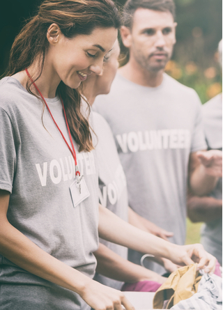 Volunteers sorting through a donation box at a non-profit event.